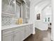 Elegant butler's pantry featuring custom cabinetry, marble counters and backsplash, and beautiful dark wood flooring at 2604 S Bryant Cir, Tampa, FL 33629