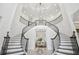 Elegant foyer with curved staircase, detailed iron railings, and a stunning chandelier creates a grand entrance at 2604 S Bryant Cir, Tampa, FL 33629