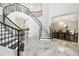Elegant foyer featuring a curved staircase, marble floors, and views of the dining room at 2604 S Bryant Cir, Tampa, FL 33629