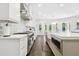 Modern kitchen featuring stainless steel appliances, white cabinets, decorative backsplash, and large island at 2604 S Bryant Cir, Tampa, FL 33629