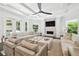 Comfortable living room featuring a fireplace, tray ceiling, and large windows offering plenty of natural light at 2604 S Bryant Cir, Tampa, FL 33629