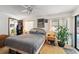 Bedroom with hardwood floors, ceiling fan, and windows with white blinds for natural light at 3093 Woodpine Cir, Sarasota, FL 34231