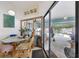 Bright dining area with a glass-top table and wicker chairs, offering views of the pool and outdoor living space at 3093 Woodpine Cir, Sarasota, FL 34231