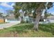 Charming home with a well-maintained lawn and mature trees providing shade, featuring a light blue exterior at 3093 Woodpine Cir, Sarasota, FL 34231