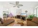 Bright living room with vaulted ceiling, fan, fireplace, and hardwood floors, creating a cozy and inviting atmosphere at 3093 Woodpine Cir, Sarasota, FL 34231