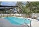 A sparkling screened-in pool is surrounded by lush landscaping and a spacious deck at 3093 Woodpine Cir, Sarasota, FL 34231