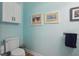 Tastefully designed powder room with a toilet, artwork and towel rack at 316 5Th N Ave, Safety Harbor, FL 34695