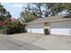 Spacious two-car garage with white doors and adjacent landscaping at 316 5Th N Ave, Safety Harbor, FL 34695