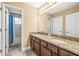 Bathroom featuring double sinks, granite countertops, and shower/tub combo with blue shower curtain at 32718 Summerglade Dr, Wesley Chapel, FL 33545