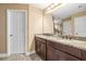Bathroom with dual sinks, granite countertops, and dark wood cabinets at 32718 Summerglade Dr, Wesley Chapel, FL 33545