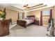 A spacious main bedroom featuring a ceiling fan, trey ceiling and carpeted floors at 32718 Summerglade Dr, Wesley Chapel, FL 33545