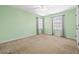 Bright bedroom features neutral carpet and trim, ceiling fan, and two windows with curtains at 32718 Summerglade Dr, Wesley Chapel, FL 33545