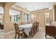 Formal dining room features an elegant chandelier and detailed wood trim, creating a sophisticated ambiance at 32718 Summerglade Dr, Wesley Chapel, FL 33545