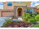 Inviting front entrance with stone accents, landscaping, and a well-manicured lawn at 32718 Summerglade Dr, Wesley Chapel, FL 33545