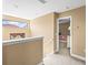 Upstairs hallway featuring neutral walls with window over stairwell and view into bedroom at 32718 Summerglade Dr, Wesley Chapel, FL 33545