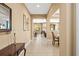 Long hallway with neutral walls, tile flooring, and an arched opening to the dining room at 32718 Summerglade Dr, Wesley Chapel, FL 33545