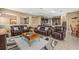 Comfortable living room area with leather furniture, neutral tones, and open access to the kitchen at 32718 Summerglade Dr, Wesley Chapel, FL 33545