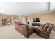 Spacious living room with neutral colored walls and carpet and comfortable leather furniture at 32718 Summerglade Dr, Wesley Chapel, FL 33545