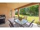 Covered patio with outdoor dining set and grill, perfect for enjoying the backyard and nature at 32718 Summerglade Dr, Wesley Chapel, FL 33545