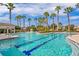 Large pool with swimming lanes, a waterfall feature, and beautiful surrounding palm trees at 32718 Summerglade Dr, Wesley Chapel, FL 33545