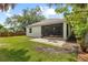 Landscaped backyard features a screened lanai and a brick patio with seating, perfect for outdoor entertaining at 3605 W Paxton Ave, Tampa, FL 33611