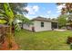 Spacious backyard features a brick patio, screened lanai, lush landscaping, and privacy fence at 3605 W Paxton Ave, Tampa, FL 33611