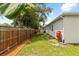 Well-maintained backyard featuring a wooden fence, green lawn, and mature tree providing shade at 3605 W Paxton Ave, Tampa, FL 33611