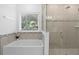 Bright bathroom featuring a soaking tub and a glass-enclosed shower at 3605 W Paxton Ave, Tampa, FL 33611