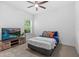 Bright bedroom with a ceiling fan and TV; showcasing natural light from the window at 3605 W Paxton Ave, Tampa, FL 33611