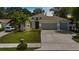 Charming single story home featuring a well-manicured lawn, a two car garage, and tropical landscaping at 3605 W Paxton Ave, Tampa, FL 33611
