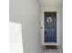Charming blue front door with a decorative wreath, welcome mat, and modern hardware at 3605 W Paxton Ave, Tampa, FL 33611
