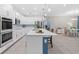 Bright kitchen with white cabinets, stainless appliances, large island, and open floor plan with dining space at 3605 W Paxton Ave, Tampa, FL 33611