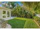 A lush backyard with green lawn, a garden, and tropical landscaping at 3711 W Barcelona St, Tampa, FL 33629