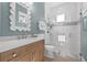 Bathroom with white and blue tile, wooden vanity, and glass shower at 3711 W Barcelona St, Tampa, FL 33629