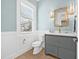 Powder room with a gray vanity, quartz countertop, decorative mirror, and wood-look floors at 3711 W Barcelona St, Tampa, FL 33629