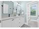 Elegant bathroom with double vanity, modern fixtures, and a bright shower with beautiful tiling at 3711 W Barcelona St, Tampa, FL 33629