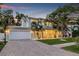 Charming two-story home featuring a well-manicured lawn, covered porch, and inviting curb appeal at dusk at 3711 W Barcelona St, Tampa, FL 33629