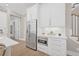 Bright kitchen with stainless steel refrigerator, microwave, quartz countertop and sleek white cabinetry at 3711 W Barcelona St, Tampa, FL 33629