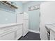 Bright laundry room features a utility sink, modern appliances, and blue accent wall at 3711 W Barcelona St, Tampa, FL 33629