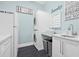 Bright laundry room boasts stacked washer/dryer, ample storage and sink with light blue walls and tile flooring at 3711 W Barcelona St, Tampa, FL 33629