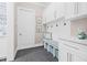 Functional mudroom featuring storage cabinets, built-in bench, hooks, and dark tile flooring at 3711 W Barcelona St, Tampa, FL 33629