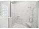 Modern shower with marble wall tiles, glass enclosure, rainfall shower head and bench seat at 3711 W Barcelona St, Tampa, FL 33629