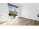 Empty bedroom with wood-look floors and glass sliding doors to the outside pool area and lush green foliage at 4612 Barracuda Dr, Bradenton, FL 34208