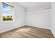Bright bedroom with wood-look floors, white walls, base molding, and a sunny window at 4612 Barracuda Dr, Bradenton, FL 34208