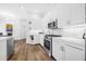 Modern kitchen featuring sleek, white cabinets, stainless steel appliances, and hardwood floors at 4612 Barracuda Dr, Bradenton, FL 34208