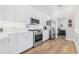 Modern kitchen with stainless steel appliances, white cabinets, quartz countertops, and wood-look floors at 4612 Barracuda Dr, Bradenton, FL 34208