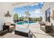 Enclosed lanai with pool, comfortable seating, and tropical landscaping creating a relaxing space at 4612 Barracuda Dr, Bradenton, FL 34208