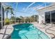 Sparkling screened-in pool with a seating area, lush landscaping, and clear blue skies at 4612 Barracuda Dr, Bradenton, FL 34208