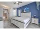 Bright bedroom features a window, a nightstand, and blue accent wall at 4951 Musselshell Dr, New Port Richey, FL 34655
