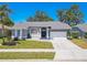 Beautifully landscaped home with a well-maintained lawn, arched windows, and two car garage at 4951 Musselshell Dr, New Port Richey, FL 34655